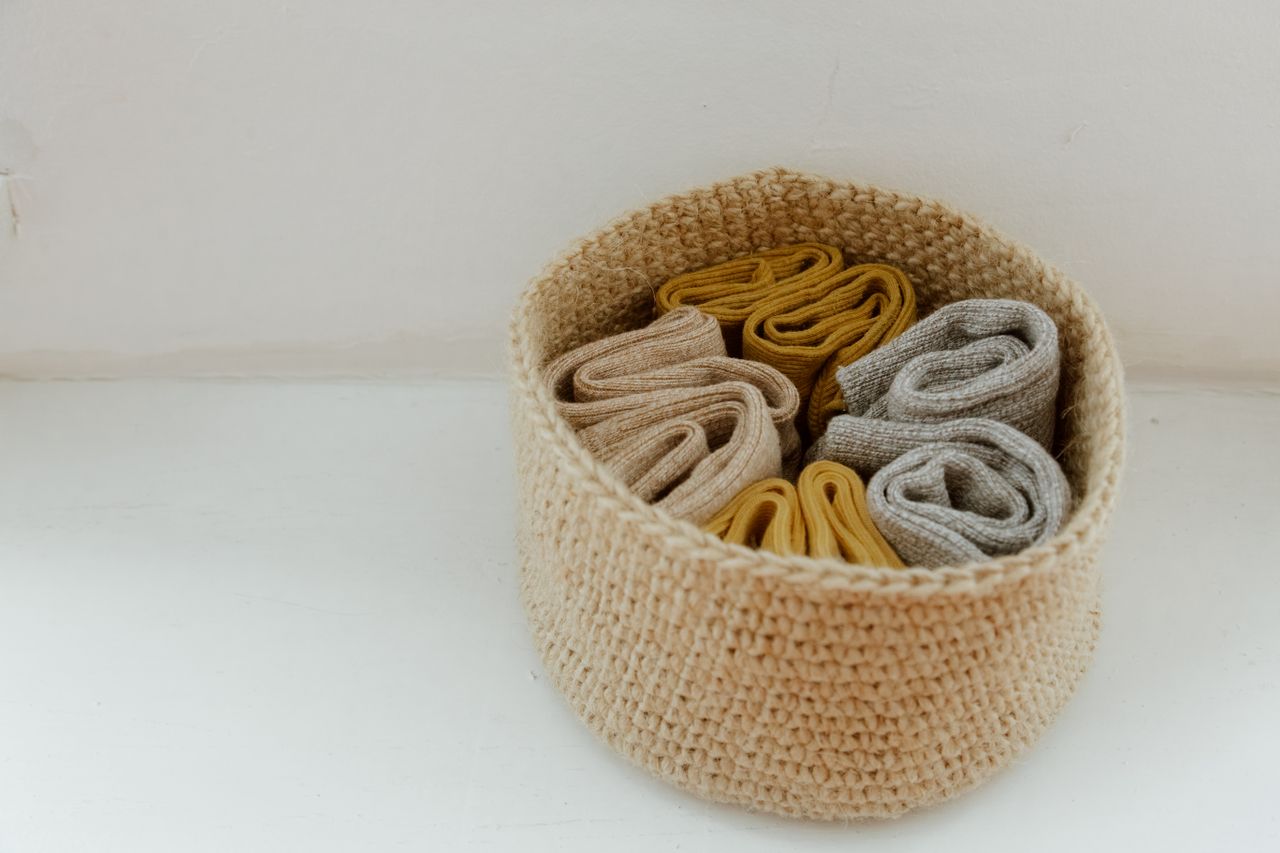 Crafting Captivating Headlines: Your awesome post title goes here A collection of rolled knitted socks in a woven basket, showcasing organization.