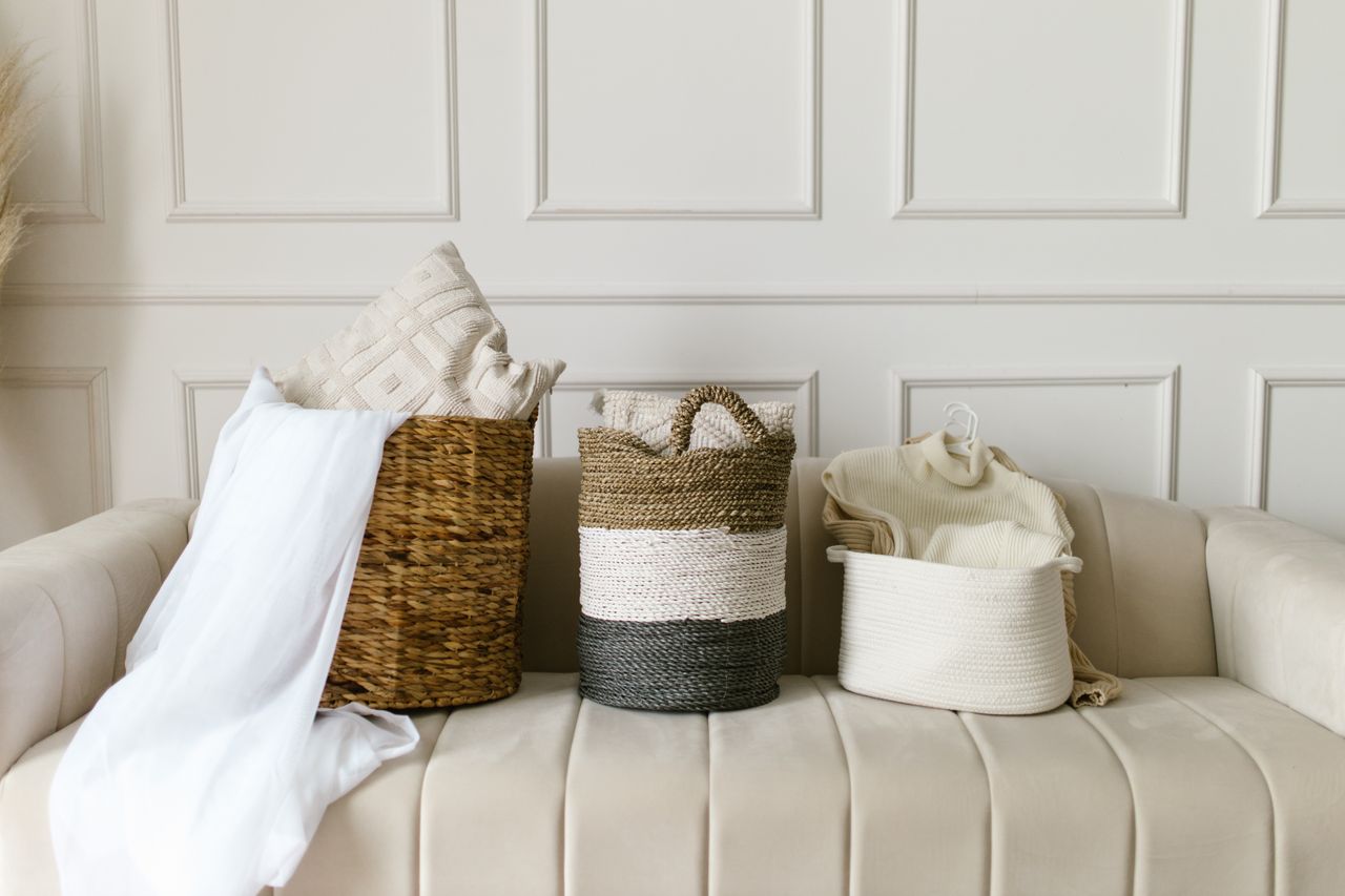 collection-05 Stylish wicker baskets on a beige sofa in a modern, cozy living room environment.