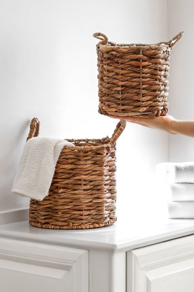 elegant-wicker-baskets-in-modern-bathroom-decor-34667272 Stylish wicker baskets with towels in a bright, modern bathroom setting, showcasing minimalistic interior design.