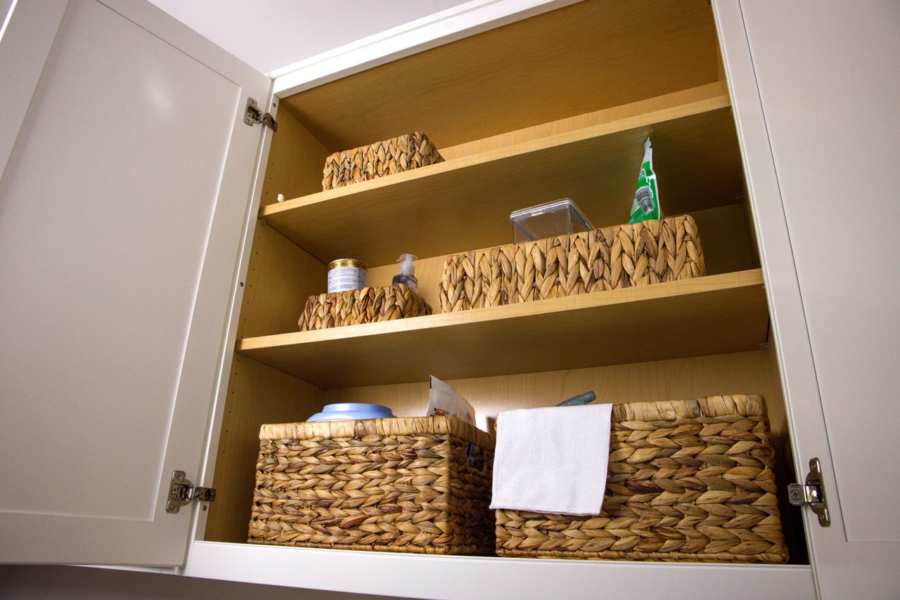 delivery-policy Neat storage in a kitchen cabinet using wicker baskets for a clean aesthetic and organization.